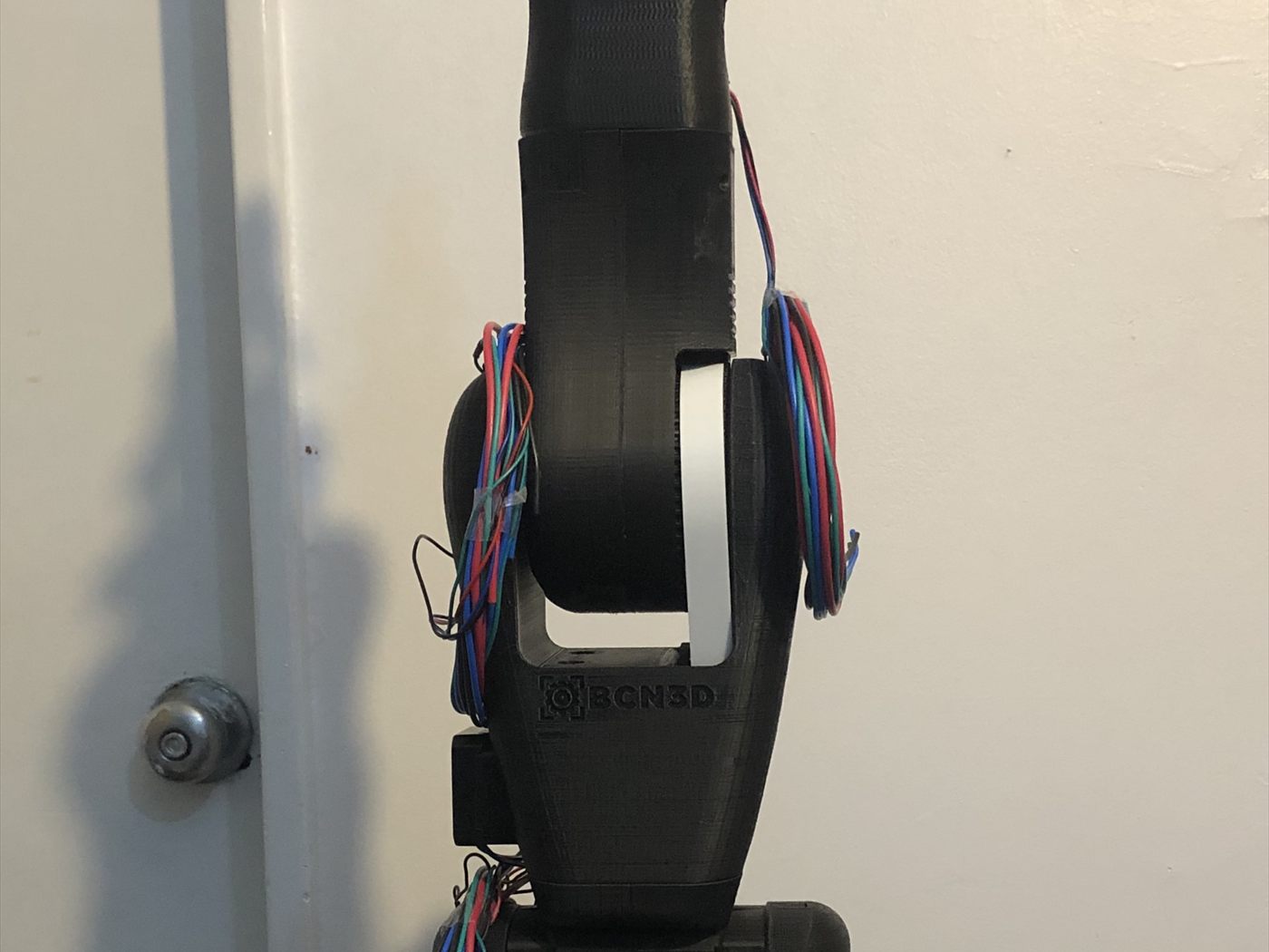 Detalle de una articulación del brazo, con el cableado saliendo de la pieza impresa.