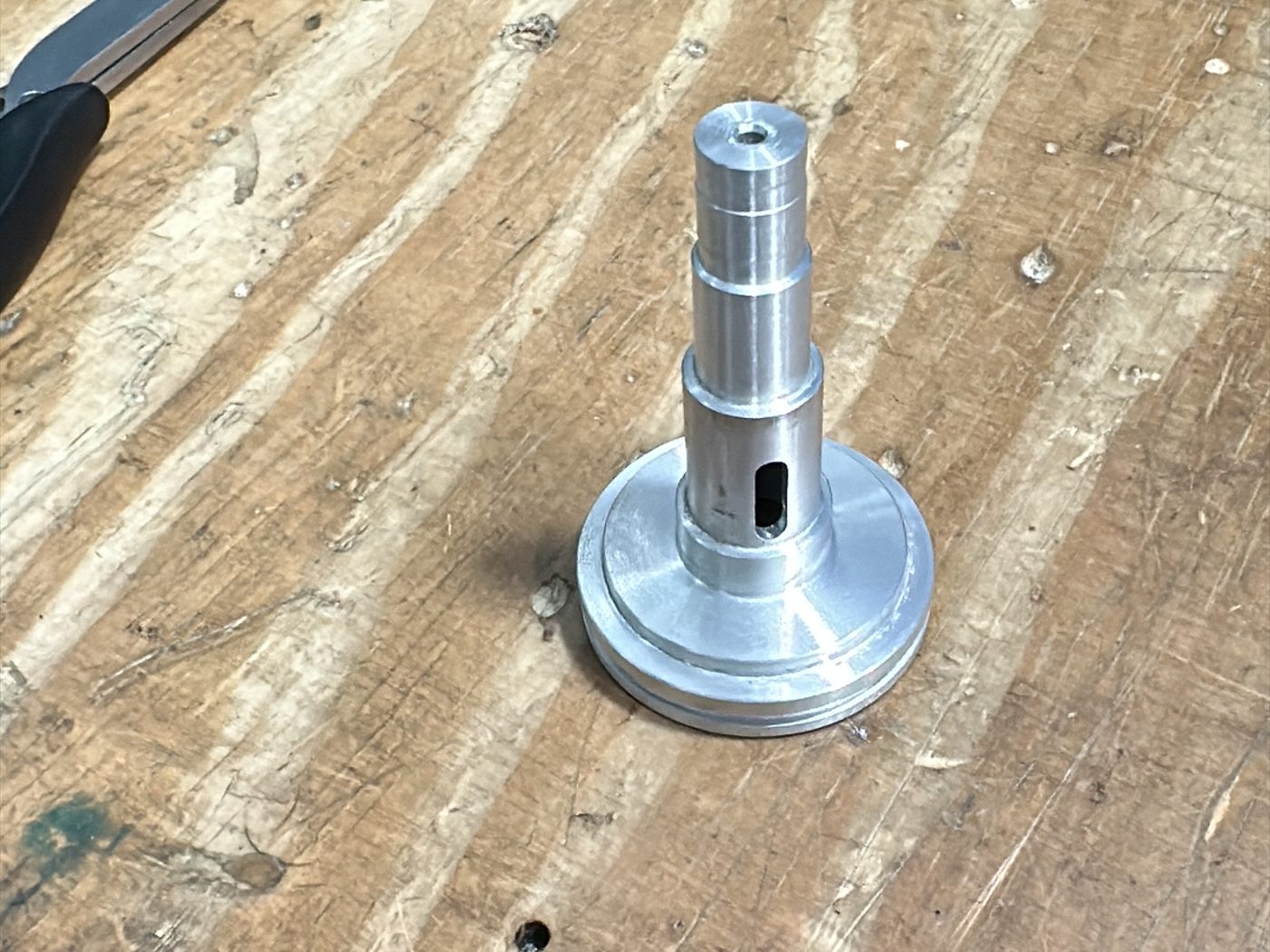 Ciclón de 37 mm mecanizado en aluminio, sobre la mesa de trabajo.