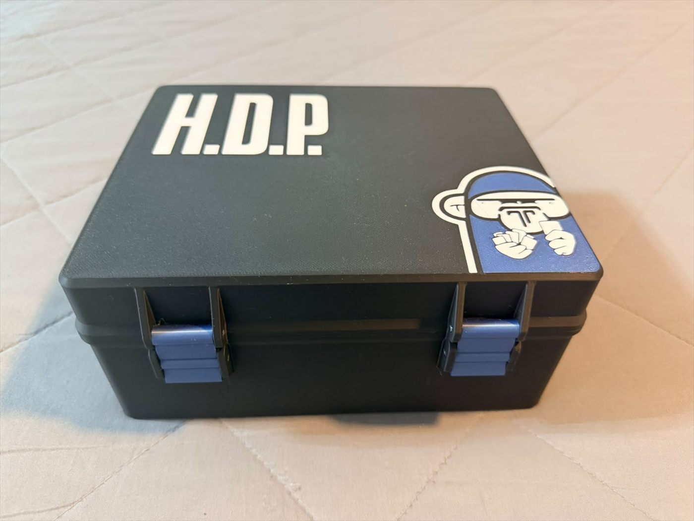 La caja impresa y terminada, con el nombre del juego en la tapa y un sticker en la esquina.