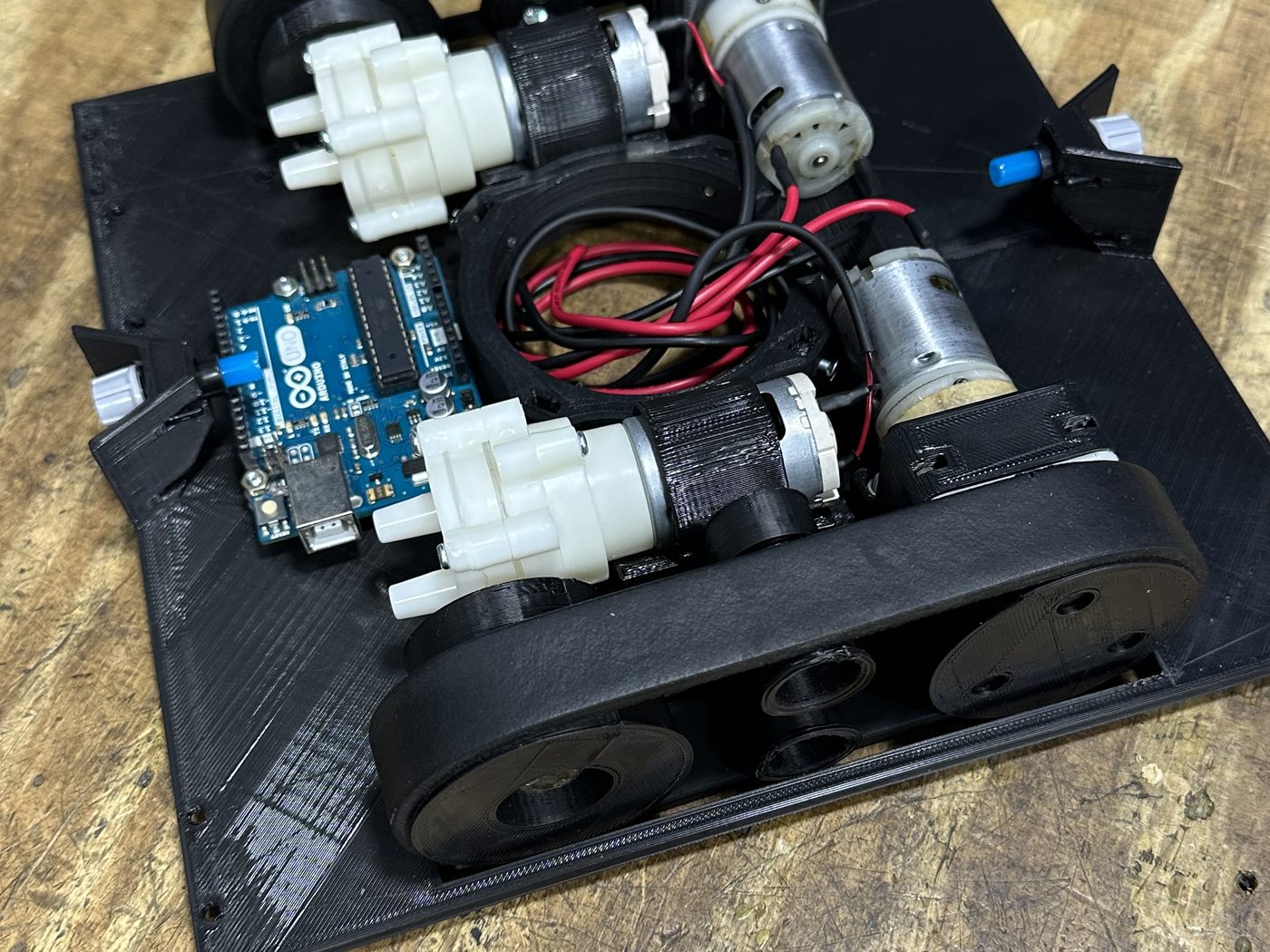 El prototipo armado sobre la mesa de trabajo, con la placa Arduino, los motores y las bombas.